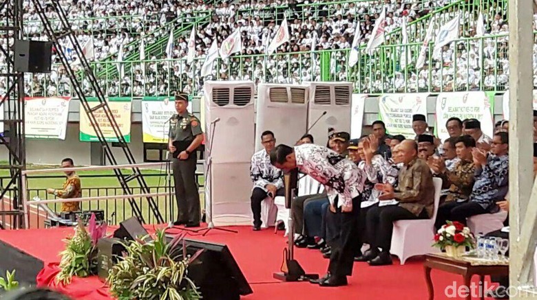 Presiden Jokowi membungkukkan badan tanda hormat kepada para guru, Sabtu (2/12/2017) foto : dc